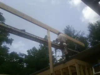 Carpenter setting a ridge beam over a new addition frame — Ice Dam Removal by Roofing Brothers in Valley Park