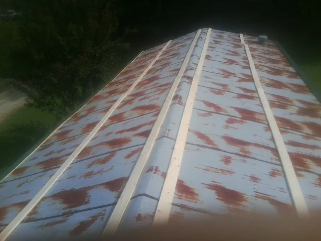 Rusted metal roof panels with new wood purlins before replacement — Storm Damage Roof Repair in Valley Park by Roofing Brothers